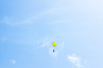Colorful balloon floating in a clear blue sky, symbolizing graduation wishes and dreams released...