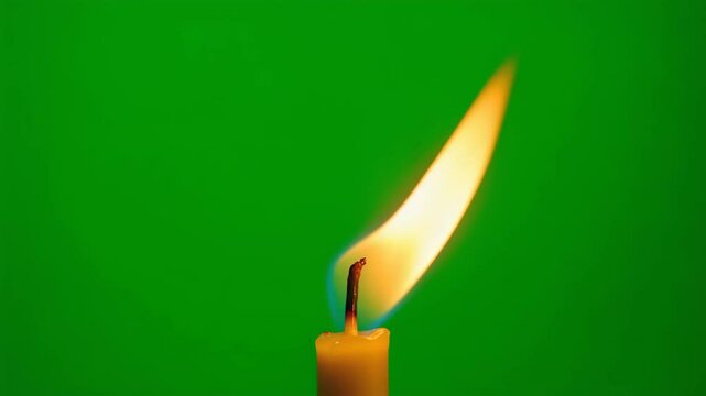 Inspiring candle flame flickering gently against a vibrant green screen background for VFX.