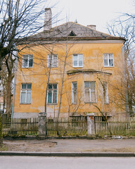 old brown building with a balcony. The building is surrounded by a fence. walking in the old town, traveling to tourist places.