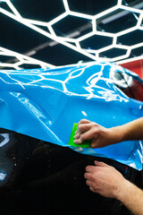 Blue PPF applied with green squeegee during detailing car to preserve finish and block damage....
