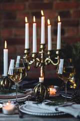 Elegant decor for Christmas family dinner. Center piece with burning candles, vintage chandelier....
