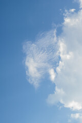 Cloud formations and crescent moon in a clear blue sky