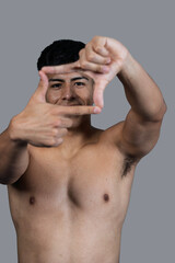 Fototapeta premium Shirtless man making a frame with his hands