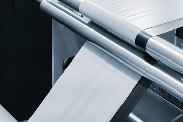 A machine with a roll of polyethylene plastic film on it. The machine is in a factory. industrial...