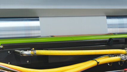 A machine with a roll of polyethylene plastic film on it. The machine is in a factory. industrial...