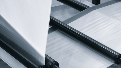 A machine with a roll of polyethylene plastic film on it. The machine is in a factory. industrial...