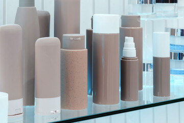 Shelf with many different types of bottles and containers. Some are clear and some are brown. There are also some blue bottles