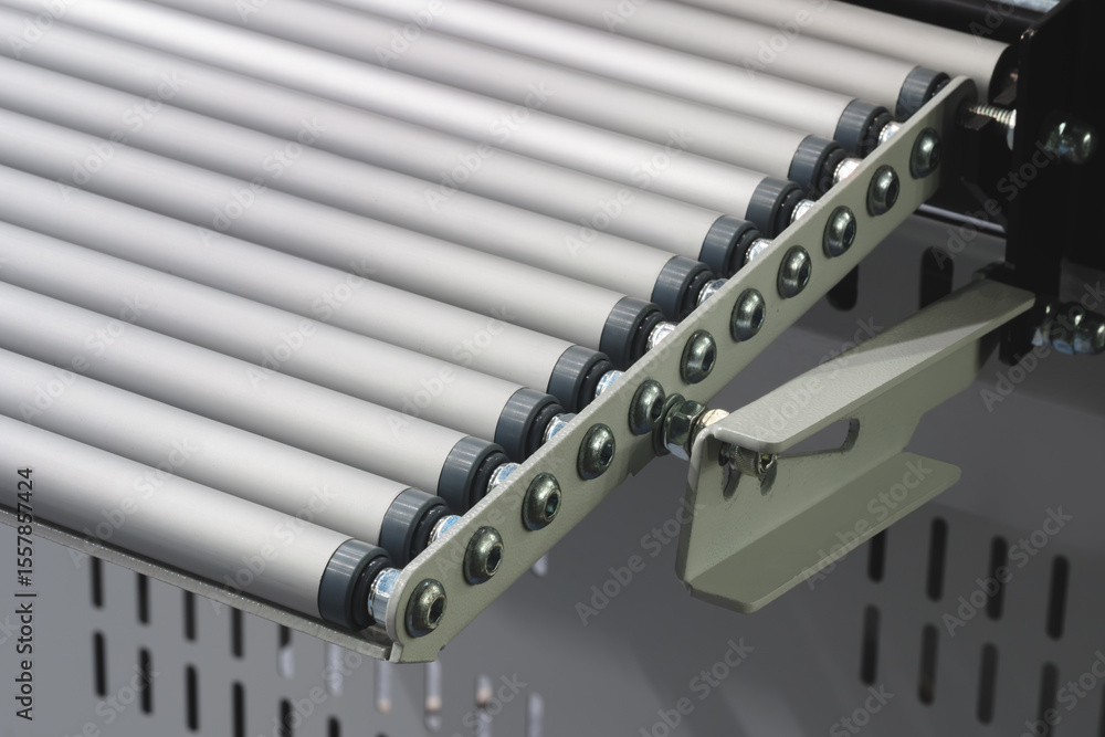 Aufkleber conveyor belt with a white handle on the end. belt is made of metal and is silver in color