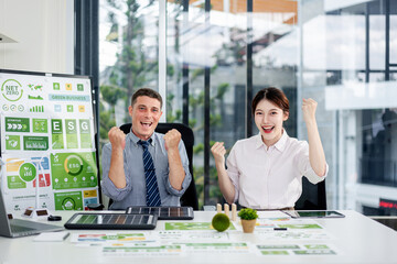 Happy business professionals celebrate green business success driving ESG environmental social...