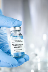 Obraz na płótnie Canvas Healthcare concept with a hand in blue medical gloves holding Chicken pox, varicella zoster virus, vaccine vial