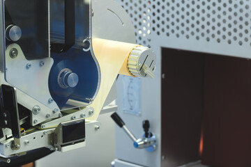 Fragment of the conveyor of sticking labeling machine. Abstract industrial background.