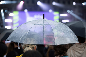 It's raining in the city. A man with an umbrella is walking through the city.