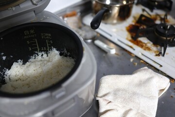 炊飯器と油汚れのコンロがある汚れたキッチン