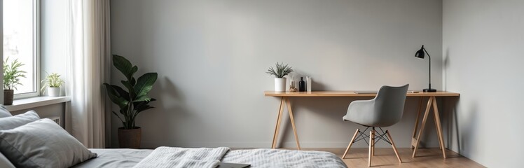 Minimalist gray bedroom corner with home office setup. Sleek wooden desk modern chair stylish decor accessories. Simple workspace in light neutral colors. Home interior design. Natural light.