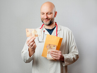 A happy doctor man in a white lab coat is holding a stack of money and an envelope . Corruption and...