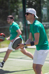 Two padel players with racket on court in action at tournament
