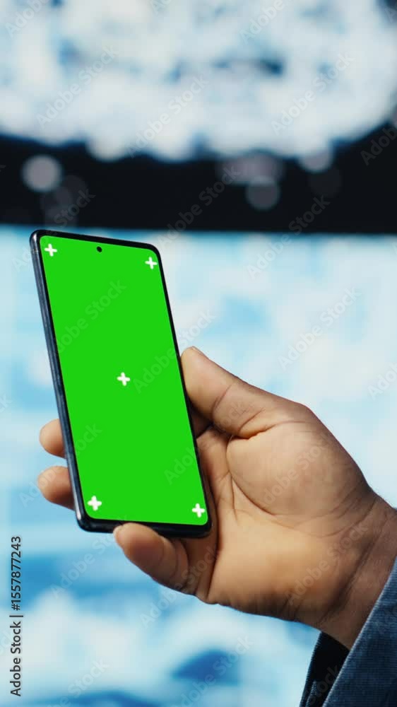 Poster vertical video focused black it professional looks at phone with green screen, standing in a digital