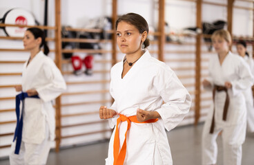 Women in fighting stances at a group karate training. Young Europeans came to the gym for a trial...