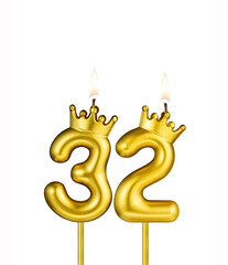 Golden number 32 birthday candle on white background