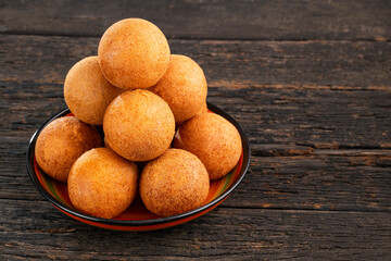 Handcrafted plate of Colombian buñuelos on a wooden background - Traditional Colombian food