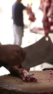 Expert butcher hones a hefty meat cleaver: Skilled hands swiftly sharpen the blade on honing steel, demonstrating practiced knife maintenance for precision cuts.