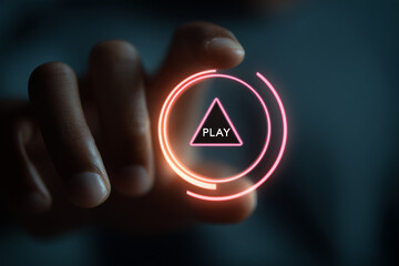 Hand pressing glowing play button on digital interface