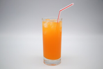 Kalter Multivitamin-Saft mit Eiswürfeln und Strohhalm