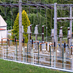 Detailed view of a high-voltage substation with transformers, insulators, and power lines. Energy...