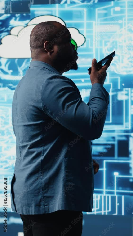 Poster vertical video african american it specialist calling a technician on his smartphone, talking about 
