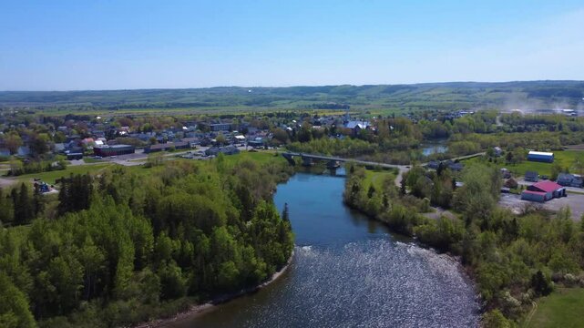 High-angle drone footage capturing the municipality of Price, surrounding forests, church, and Mitis River crossing. Quebec, Canada, 2025.