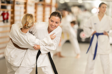 Obraz premium Young women in kimonos practice judo. Women practice wrestling. Group Judo Training