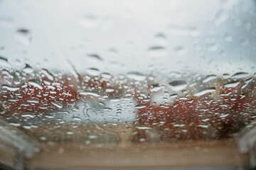Rainy window with blurred view of Prague city in background