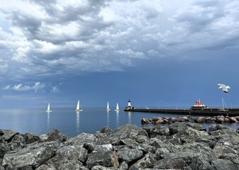 Sailboats on Lake Superior with lighthouse on the pier