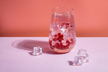 Alcohol free pomegranate drink on pink background.