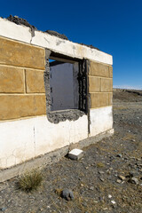 Abandoned building structure with a large window opening, showcasing weathered walls and cracked...