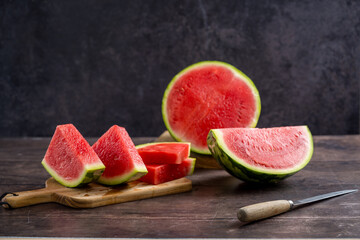 Slices of fresh watermelon on the rustic wooden table, dark background