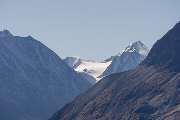 Majestic mountain range with snow-capped peaks and rocky slopes, showcasing the beauty of nature,...