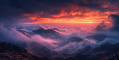 Fiery sunset paints a dramatic sky above a sea of clouds nestled in rolling mountain peaks, casting a vibrant, purple-orange glow