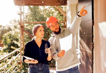construction worker and client architect at a construction site inspect plan use tablet.architect...