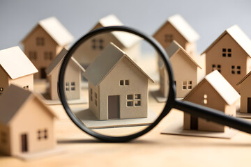 Finding the perfect property is like searching through paper houses with a magnifying glass, focusing on details for real estate success.