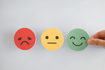 Hand choosing happy smile face, good feedback rating and positive customer review, mental health...