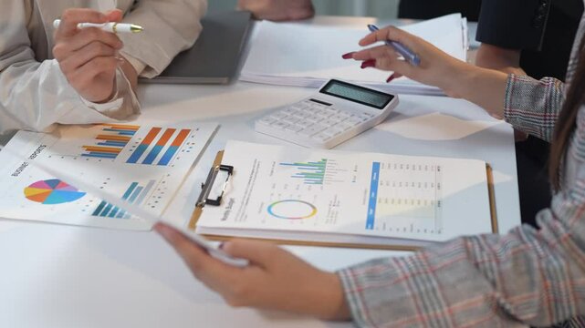 Businesswomen team working with financial reports using calculator