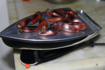 Araucaria pine nuts roasted in a creative and funny way on the electric iron