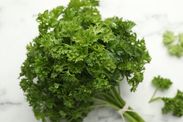 Bunch of fresh parsley on white marble table, closeup
