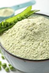 Protein powder in bowl and green peas on table, closeup