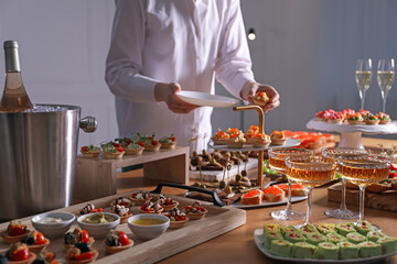 Buffet menu. Woman taking tasty tartlet from table, closeup
