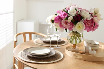 Beautiful table setting with bouquet of peonies in dining room, closeup