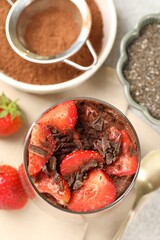 Delicious chocolate pudding with chia seeds and strawberries on table, flat lay