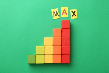 Colorful cubes and word Max on green background, top view