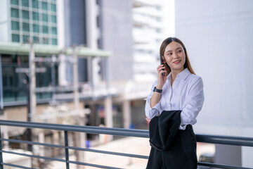Businesswoman talking on smartphone on office building balcony